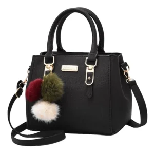 Sac main noir pompon vintage avec accessoires dorés, deux poignées, une bandoulière détachable, et trois pompons en fourrure rouge, vert et blanc