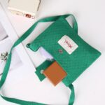 Mini sac à main vert style pochette effet tricoté posé sur une table