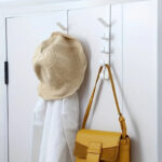 Porte sac à main mural à cinq crochets fixés au mur avec une sac à main jaune accroché
