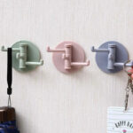Porte sac à main rotatif à 3 branches de tros couleurs différentes fixés au mur