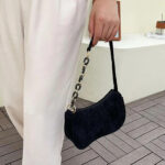 Sac à main ado noir en velours côtelé poprté à la main par une femme