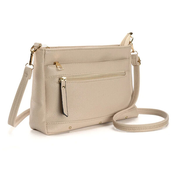Sac à main beige à bandoulière en simili cuir souple, vue de trois quart sur un fond blanc.