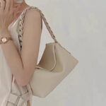 Sac à main beige élégant et design en cuir porté à l'épaule