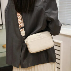 Sac à main beige petit format à bandoulière, porté par une femme de dos.