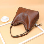 Sac à main camel élégant style vintage posé sur fond crème