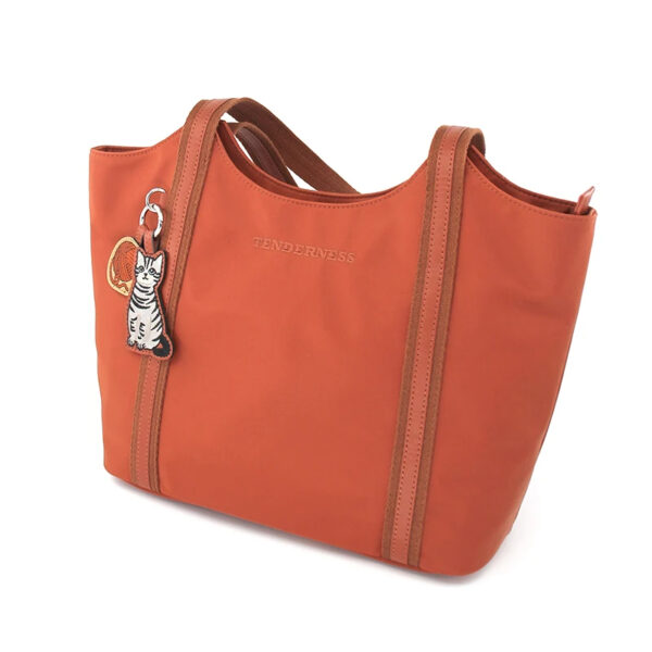 Sac à main cours orange et pratique en nylon sur fond blanc