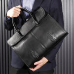 Sac à main homme cuir noir chic et sophistiqué tenu par un homme