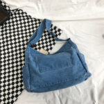 Sac à main en jean rétro style japonais posé sur un canapé blanc avec des damiers