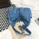 Sac à main en jean rétro style japonais posé sur canapé avec un journale à coté