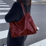 Sac à main lycée décontracté style rétro rouge porté à l'épaule