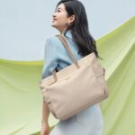 Sac à main lycée pratique et tendance porté à l'épaule par une jeune femme