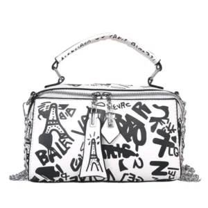 Sac à main original blanc avec des graffitis noirs, incluant des dessins de la Tour Eiffel. Le sac possède une poignée et des détails métalliques.