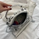 Sac à main originalblanc avec des graffitis noirs, vaec des motifs tour eiffel porté à l'épaule ouvert avec vue intérieure