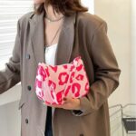 Sac à main rose décontracté avec motifs léopard porté par une femme