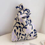 Sac à main tissus chic et raffiné avbec des motifs bleu marine et parme posé sur une table