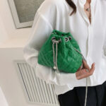 Sac à main vert élégant matelassé en similicuir oprté par une jeune femme