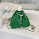 Sac à main vert élégant matelassé en similicuir posé sur une étagère blanche