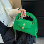 Sac à main vert raffiné et tendance, présenté à la main