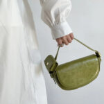 Sac à main vert en similicuir petit format à bandoulière porté à la main