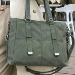 Sac à main vert tendance et spacieux, porté au bras par une femme en exterieur