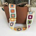 Sangle de sac à main en nylon avec motif floral, de couleur blanche, accroché à un sac marron