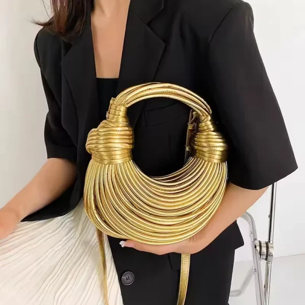 Sac-main-doré-luxe-soirée-design-noué-03 Sac à main doré luxe de soirée desig noué tenu par une femme