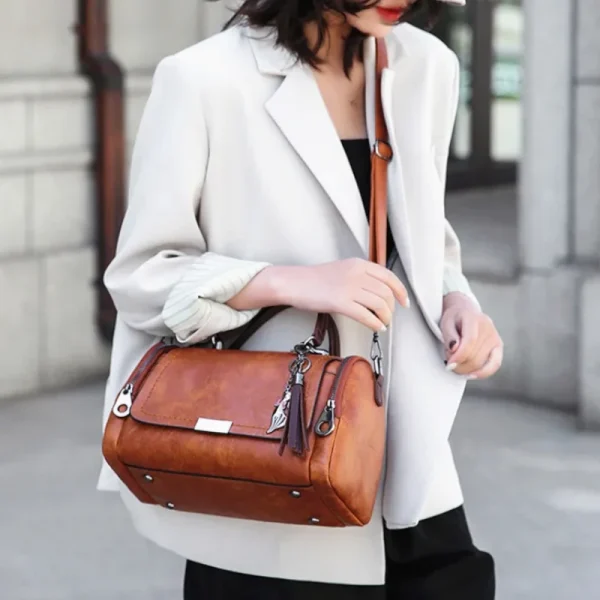 Sac-main-marron-vintage-pompon-02 Sac à main marron vintage avec pompon porté à l'épaule par une femme