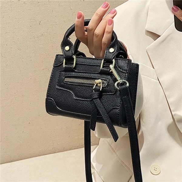 Mini sac à main noir design et élégant porté à la main par une femme