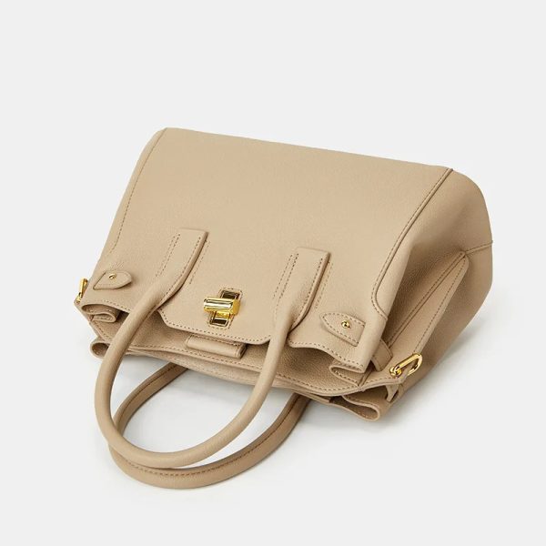 Sac à main beige en simili cuir élégant et spacieux,posé sur le coté