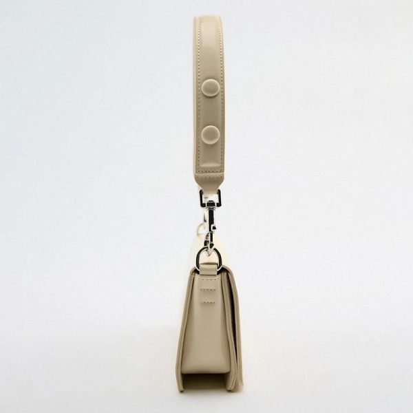 sac-main-beige-simili-cuir-tendance-petit-format-02 Sac à main beige en simili cuir tendance petit format vue de profil , sur un fond blanc.