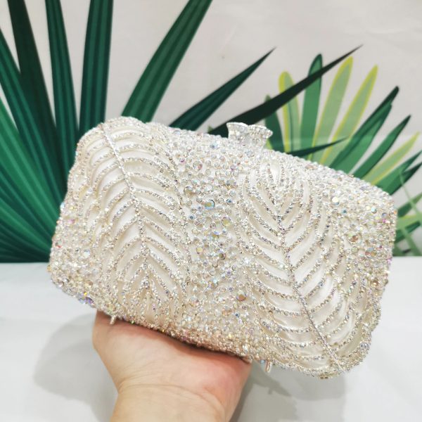 sac-main-blanc-brillant-strass-03 Sac à main blanc brillant avec strass dans la main d'une personne