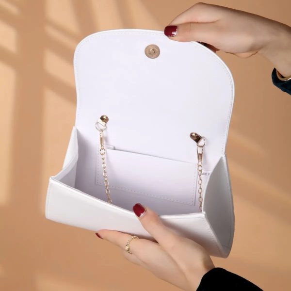 sac-main-blanc-epure-chic-03 Sac à main blanc épuré et chic blanc présenté ouvert par une main de femme avec vue de l'intérieur