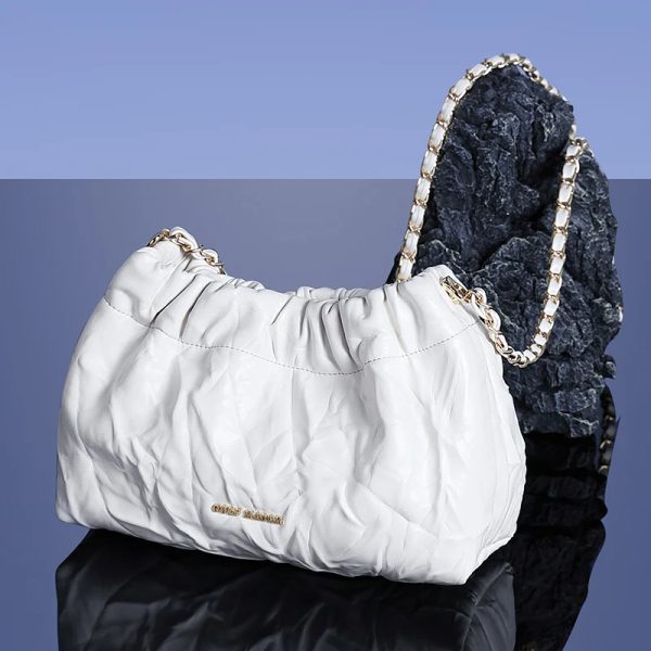 sac-main-blanc-souple-chic-01 Sac à main blanc souple et chic posé sur un support gris