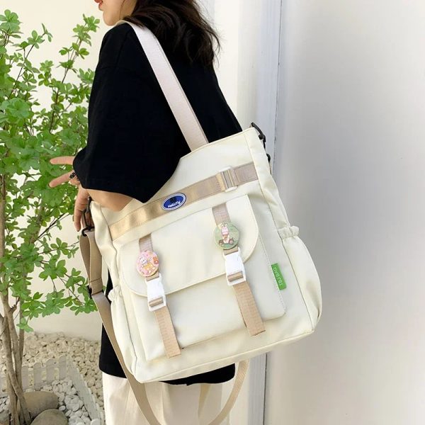 Sac à main cours de grande capacité en toile porté à l'épaule par une jeune femme