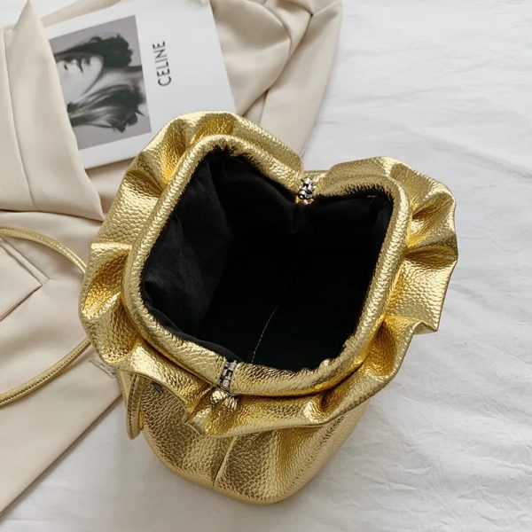 Sac à main doré élégant avec bandoulière sur fond blanc ouvert avec vue intérieure