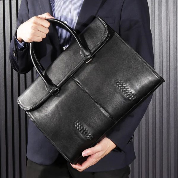 sac-main-homme-cuir-noir-chic-sophistique-04 Sac à main homme cuir noir chic et sophistiqué tenu par un homme