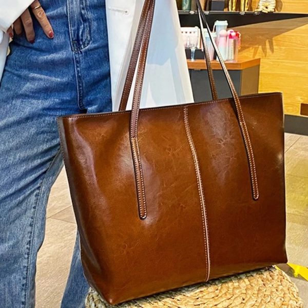 sac-main-marron-cuir-grand-format-01 sac à main marron en cuir grand format tenu ar une femme