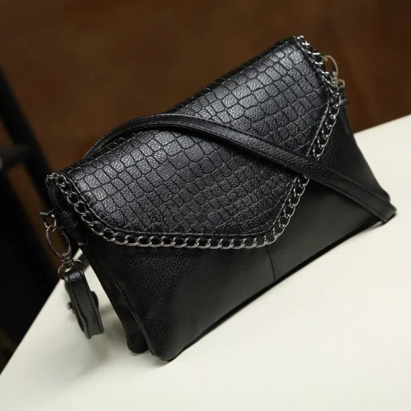 sac-main-noir-effet-crocodile-02 Sac à main noir effet crocodile sur une table sur fond marron