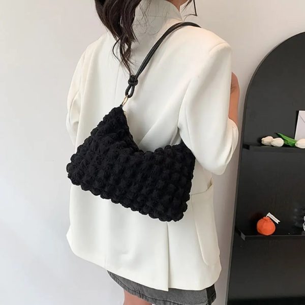 Sac à main original et moderne en matière souple porté à l'épaule
