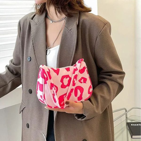 Sac à main rose décontracté avec motifs léopard porté par une femme