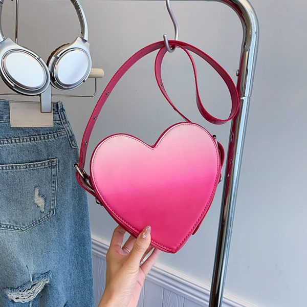 sac-main-rose-raffine-forme-coeur-03 Sac à main rose raffiné en forme de coeur accroché sur une penderie