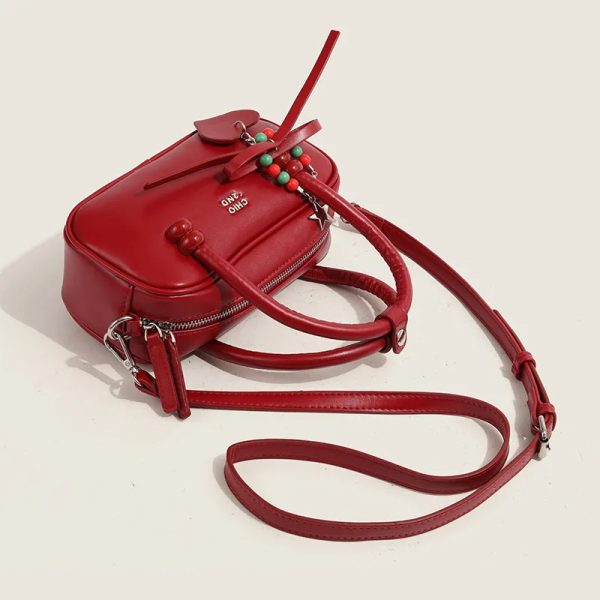 sac-main-rouge-chic-tendance-04 Sac à main rouge chic et tendance posé à plat sur une table