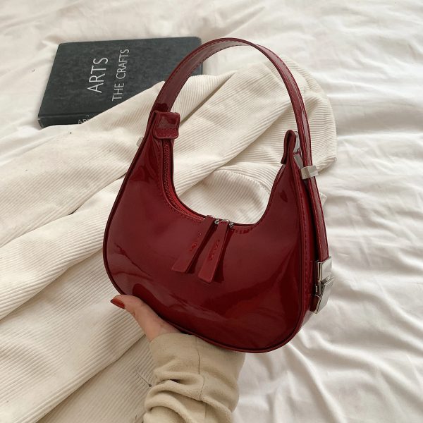 Sac à main rouge raffiné et polyvalent présenté par une main de femme