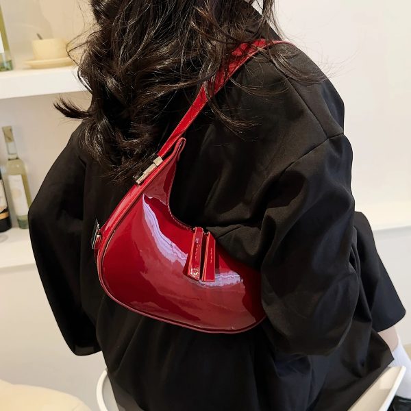 Sac à main rouge raffiné et polyvalent oprté à l'épaule par une jeune femme