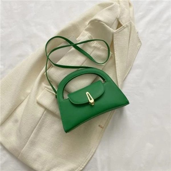 sac-main-vert-raffine-tendance-01 Sac à main vert raffiné et tendance, posé sur une veste blanche