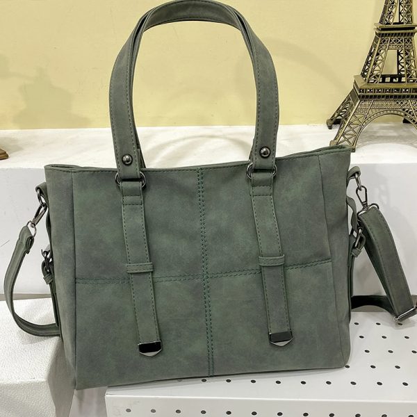sac-main-vert-tendance-spacieux-04 Sac à main vert tendance et spacieux, posé sur un support avec une Tour Eiffel dans le fond