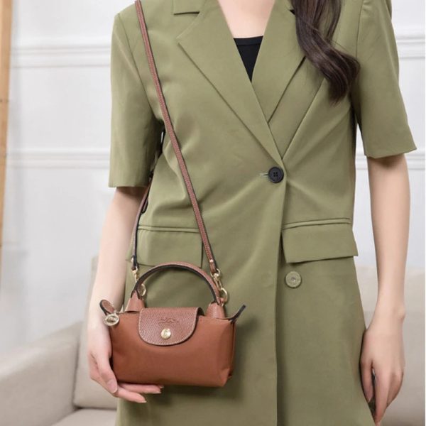 Sangle de sac à main réglable marron en simili cuir portée à l'épaule gauche par une femme
